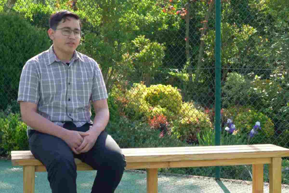 Angel David seduto su una panchina