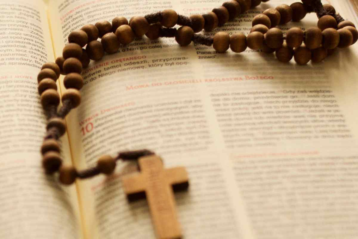 Croce e rosario su un testo sacro